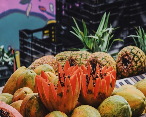 A beautiful assortment of fresh tropical fruits including papaya and bananas on a rustic table market setup